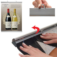 By hand, simply snap open both snap bar rails, top and bottom, slide graphic or poster in, and snap close 